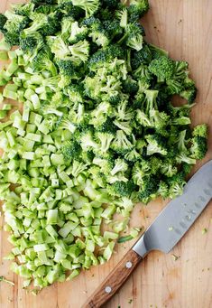 chopped broccoli on a cutting board next to a knife