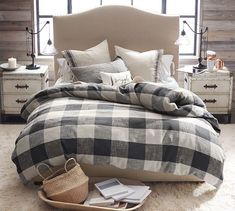 the bed is made with plaid sheets and pillows