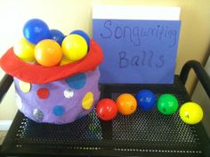 a basket filled with balls sitting on top of a black tray next to a sign