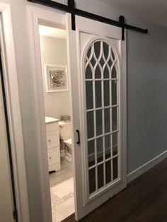 an empty room with white doors and wood floors