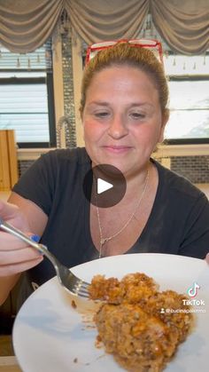 a woman sitting at a table with a plate of food