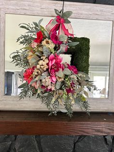 a bouquet of flowers sitting on top of a mantel in front of a mirror