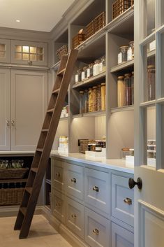 a ladder is in the middle of a kitchen with cabinets and drawers on both sides