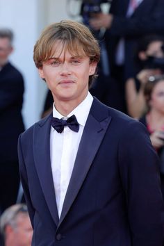 a young man in a tuxedo and bow tie at the venice film festival