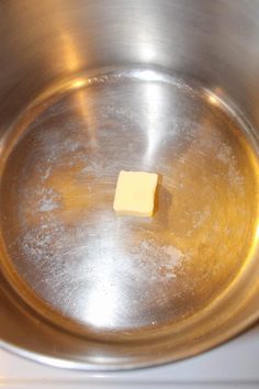 a square of butter in a metal bowl