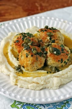 a white plate topped with mashed potatoes and meatballs