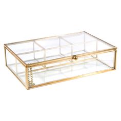 a large glass box with gold trimmings on the bottom and sides, filled with jewelry