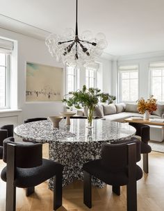 a dining room table with chairs around it and a couch in the backround