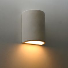 a white wall light mounted on the side of a wall