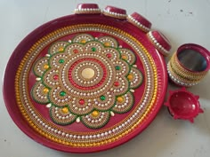 a red tray with gold and green designs on it