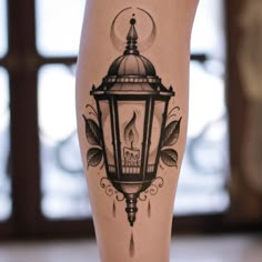 a tattoo on the leg of a woman with a candle and leaves around her legs