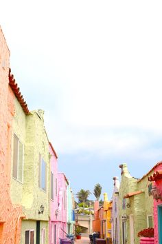 a row of brightly colored houses on the side of a road