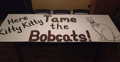 a table with a sign that says here kittyy tame the bobbats