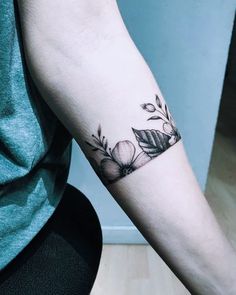 a woman's arm with a flower tattoo on the left side of her arm