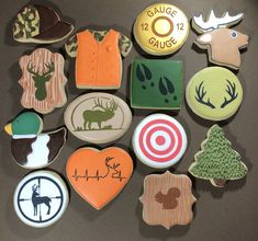 decorated cookies are arranged on a table with different designs and colors, including deer, elk, moose, arrow, heart, target