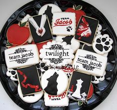 decorated cookies in the shape of dogs and their names on a black plate with red accents