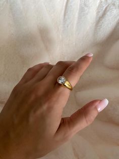 a woman's hand with a gold and diamond ring on top of her finger