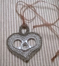 a crocheted heart ornament with scissors hanging from it's side