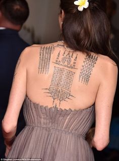 the back of a woman's dress with tattoos on it