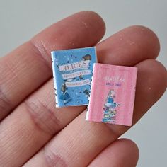 a tiny book is held in someone's hand with the cover pulled back to reveal it