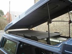 the back end of a van with an awning on it's roof rack