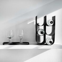 two wine glasses and some speakers on a shelf