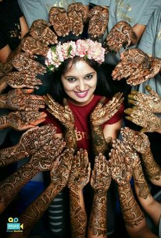 a woman is surrounded by henna's and hands with flowers in her hair