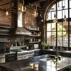 an industrial style kitchen with exposed brick walls and large windows, stainless steel counter tops