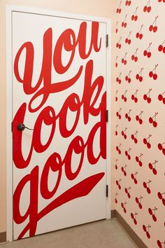 an open door with the words you look good painted on it next to wallpaper