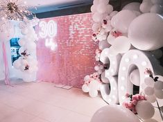 balloons and flowers decorate the entrance to a 30th birthday party in pink, white and silver