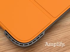 an orange ipad case sitting on top of a wooden table with the words amplify below it