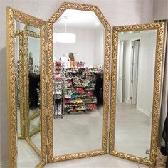 a large gold mirror sitting on top of a floor next to a closet filled with shoes