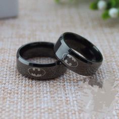 two black batman rings sitting on top of a table