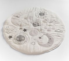 a white round rug with sun, moon and clouds on it