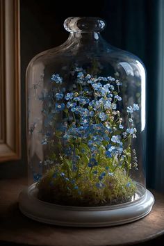 a glass clochet with blue flowers in it