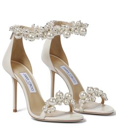 a pair of white high heels with pearls