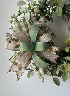 a wreath with green and white flowers on it