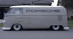 an old vw bus parked in front of a house with the word porsche written on it