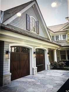 a large house with two garage doors on the front and one door open to let in light