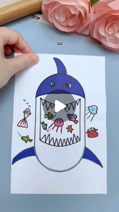 someone is drawing a shark with their mouth open