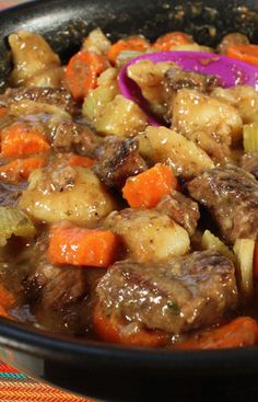 a bowl filled with meat and vegetables on top of a table