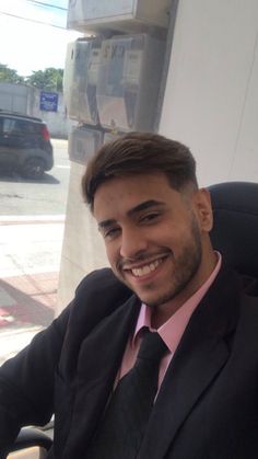 a man sitting in an office chair smiling for the camera