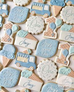 cookies decorated with blue and white icing are arranged on a table