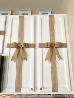 two brown bows tied on white cabinets in a kitchen