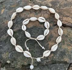 a necklace made out of seashells on a rock