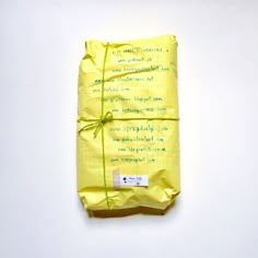 a package wrapped in yellow paper with green writing on it