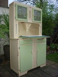 an old fashioned kitchen cabinet with two glass doors on the top and bottom, sitting outside