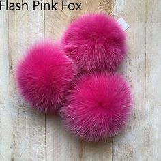 two pink furry slippers sitting on top of a wooden floor