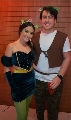 a man standing next to a woman in a costume