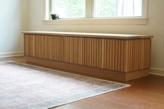 an empty room with a rug, window and radiator on the floor in front of it